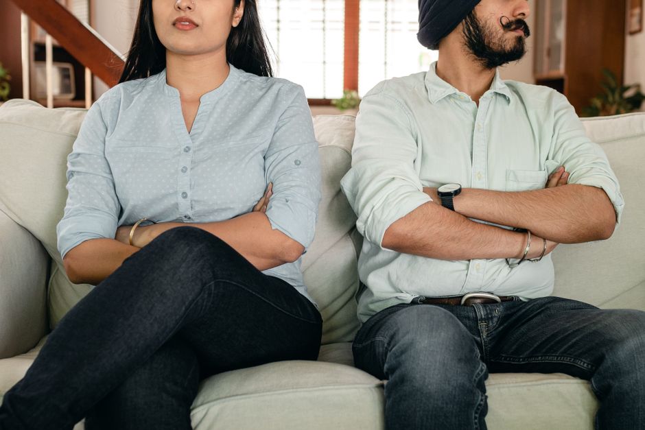 paar sofa arme verschraenkt schweigen distanz pflege belastung partnerschaft