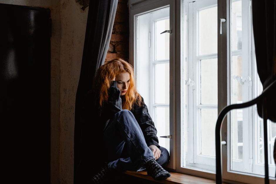 schuldgefuehle pflegende angehoerige frau nachdenklich fenster erschoepft