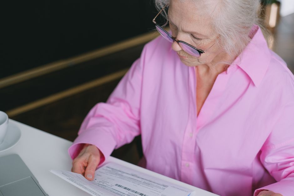 seniorin liest dokument antrag rentenversicherung pflegeperson